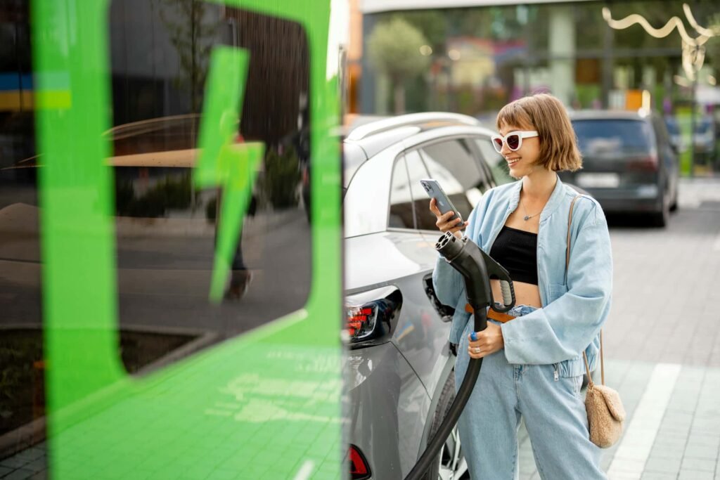 woman-charging-her-car-on-public-fast-charger-2023-11-27-05-21-17-utc - Tyre Shop Singapore | Tire Pte Ltd | tyre shop singapore | tire pte ltd