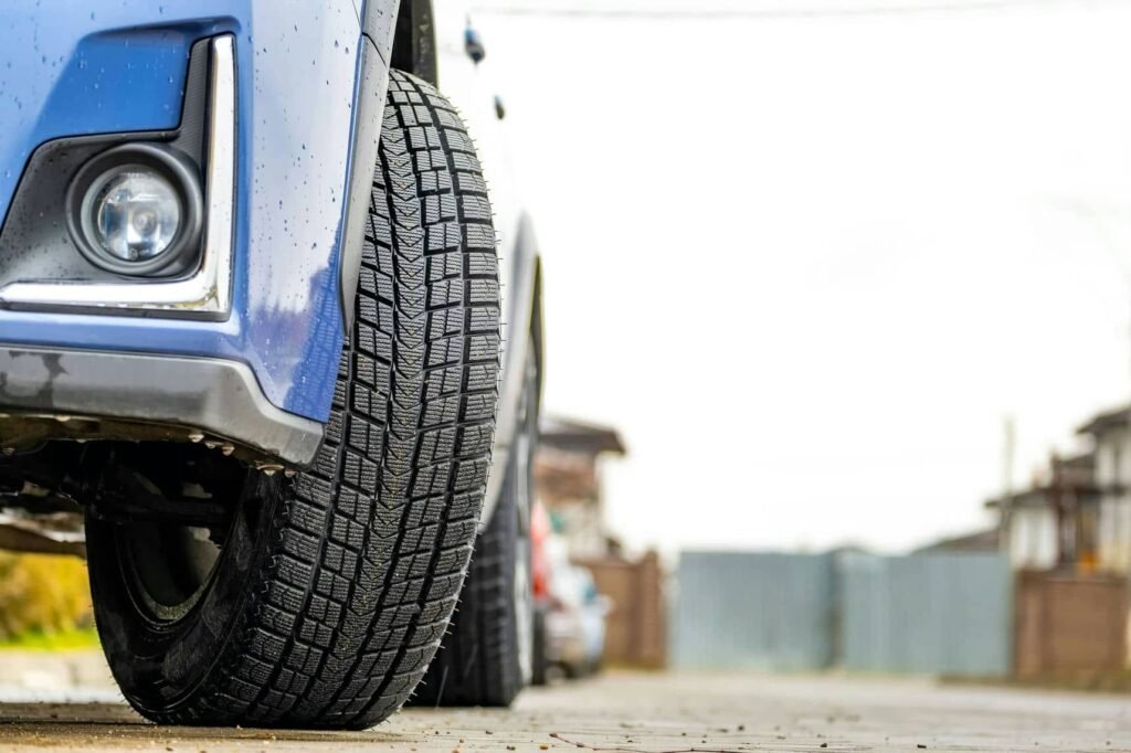 Closeup of parked car on a city street side with new winter rubber tires. - Tyre Shop Singapore | Tire Pte Ltd Hybrid tyres | tyre shop singapore | tire pte ltd